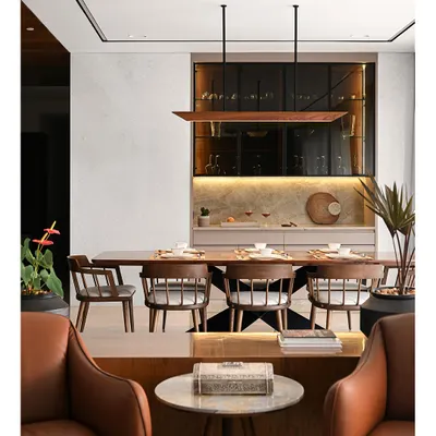 The living and dining area of a rustic and contemporary home we designed. This space showcases our ability to create airy, warm, and welcoming residential interiors through a careful selection of materials like marble, wood, and high-end furniture.