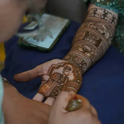 A candid moment of me creating a groom portrait for a bridal mehndi. I use a phone for reference to get the details just right.