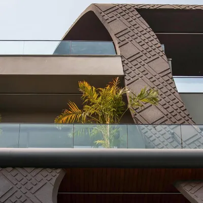 A close-up of the wave-form facade, showcasing the intricate concrete grooving work. This detail, inspired by fluid beauty, blends aesthetics and sustainability, creating a texture that plays with light and shadow.