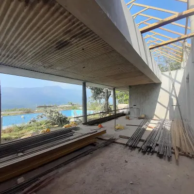 An under-construction view of a boutique hotel in Chikmagalur, where the concrete form is shaped to frame the breathtaking mountain vistas.