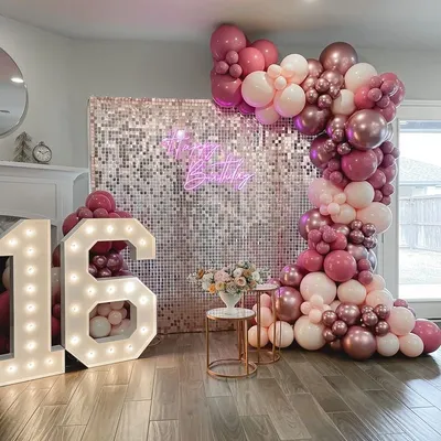 Turning 16 is a huge milestone. For this sweet sixteen party, I designed a glamorous photo wall with a silver sequin backdrop, a custom neon sign, and a cascade of pink and metallic balloons.