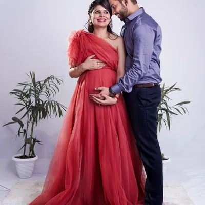 A beautiful portrait of an expecting couple, with the mother-to-be in a stunning red gown. We focus on capturing the connection and excitement you share as you wait for your little one.