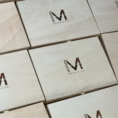 A clean and professional look for corporate gifting. These wooden boxes feature the 'Modern Spaaces' logo engraved directly onto the lid, creating a lasting brand impression.