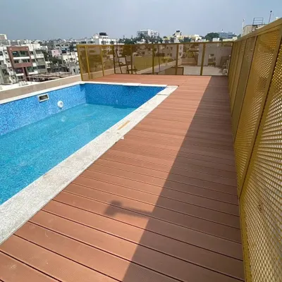 This rooftop pool area was upgraded with our water-resistant WPC decking. The warm wood-look finish provides a safe, non-slip surface that beautifully complements the cool blue of the pool tiles.