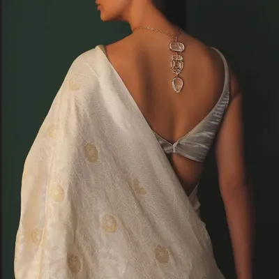 The back of a saree look is just as important as the front. Here, a stunning carved necklace by Hanut Singh is styled as a back accessory, adding a surprising and artistic element to this elegant white saree.