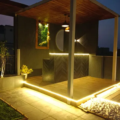 A modern pergola at night. The structure is highlighted by integrated LED strip lights, creating a stunning architectural feature and providing beautiful ambient lighting.