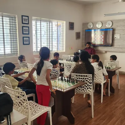 A view of our classroom during a lesson. A coach uses a digital display to explain a game, while students follow along on their own boards, creating an interactive learning environment.