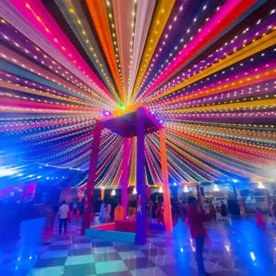 A stunning night view of a multi-colored canopy illuminated with thousands of fairy lights. This creates a magical, starry effect for a Sangeet or reception party.