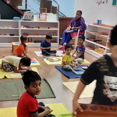 We have an open-door policy for parents. Here, a parent observes the classroom, a practice common in pure Montessori environments. This allows parents to see their children's progress and understand our child-led learning philosophy.