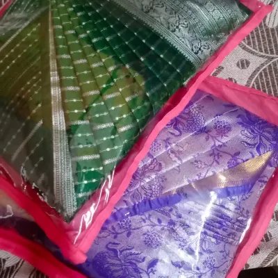 Two sarees, pleated and packed in individual saree bags with a clear window. This keeps them organized and protected until you're ready to wear them.