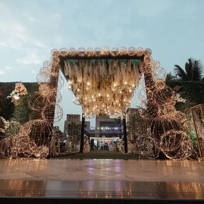 This entrance was designed to be a spectacle of light and texture. I used intricate wire-frame spheres wrapped in fairy lights and a ceiling of hanging white florals to create a magical, immersive experience.