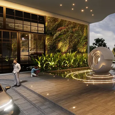 A close-up of the drop-off area at the RRBC entrance plaza, highlighting the vertical green wall and the base of the sculptural water feature. This view shows the careful integration of biophilic design and modern materials to create a sophisticated and welcoming atmosphere.