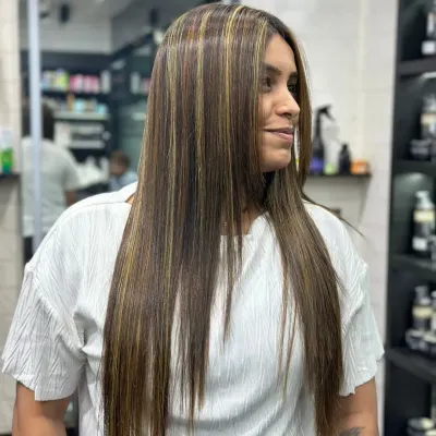 A perfect example of a smoothing treatment combined with subtle highlights. The hair is left incredibly straight, glossy, and frizz free, showing off the new color dimension beautifully.