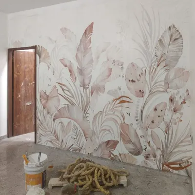 This botanical wallpaper features large, overlapping leaves in soft, muted tones. It’s a perfect example of an in-progress installation, showing how a nature-inspired mural can bring a sense of calm and elegance to a room.