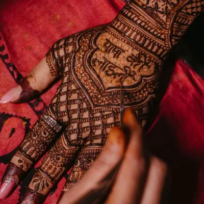 The moment of creation. Here I am carefully writing "Papa ki Laadli" on the bride's hand, a touching tribute to her father.