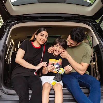 A candid moment from the MG Motor family campaign. The father interacts with his son in the back of the car, creating a warm, genuine image that speaks to family values.