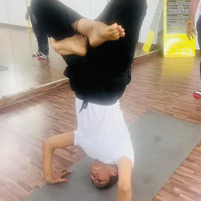 Mastering the tripod headstand, or Sirsasana II, with a lotus leg variation. This inversion requires immense core strength, balance, and concentration.