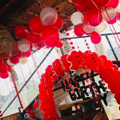 This birthday setup shows how a simple red and white color scheme can make a big impact. I created a full balloon arch over the seating area and filled the ceiling with balloons to create a festive party environment.