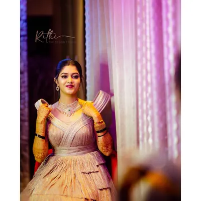 Our gorgeous bride ready for her cocktail party in a custom shimmered rose gold gown. The design features a tiered skirt and unique sculpted shoulders for a modern, glamorous look.