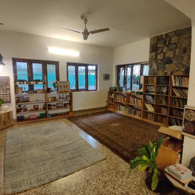 An overview of our elementary classroom. The space is open and uncluttered, with materials organized on low shelves, inviting children to choose their own work. The stone wall and wooden furniture bring the texture of the natural world indoors.