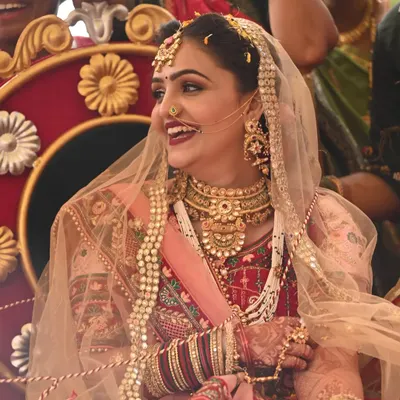 The pure joy of a bride on her wedding day. This look features a classic bold lip and defined eyes, a timeless combination for a traditional Gujarati wedding ceremony.