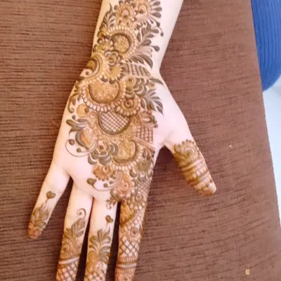 A classic Arabic style mehndi design. The pattern flows diagonally across the back of the hand, featuring floral and paisley elements with shaded details.