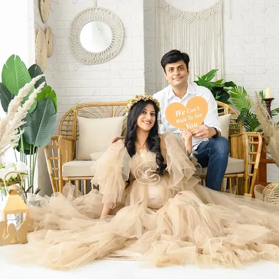 A lovely couple's portrait in our full boho-chic setup. The scene is filled with natural textures, from the rattan couch to the pampas grass and "LOVE" sign, creating a warm and inviting atmosphere.