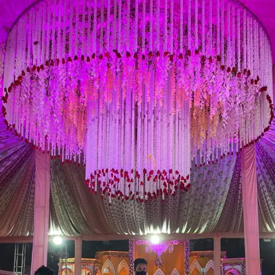 I am absolutely in love with creating massive, hanging floral chandeliers. This one, made of tuberose and rose petals, becomes the stunning centerpiece of the entire wedding tent.