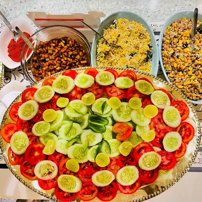 A fresh and colourful salad platter, featuring sliced tomatoes, cucumbers, and lemon. Alongside are bowls of kosambari and other healthy preparations, perfect for a light and healthy option.