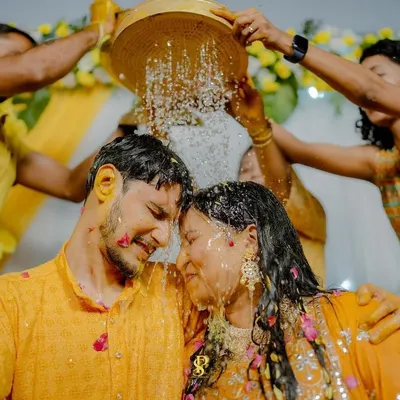 A shower of blessings and petals! This is a moment of pure bliss during the Haldi, where the couple is surrounded by the love and playful energy of their family and friends.