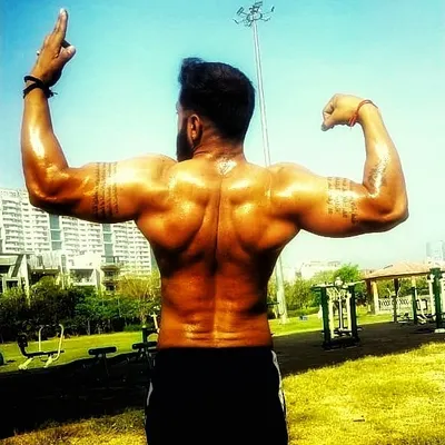 Posing after an intense outdoor workout. A well-developed back shows true strength and dedication. This kind of muscle definition is built with hard work and fueled by quality supplements.