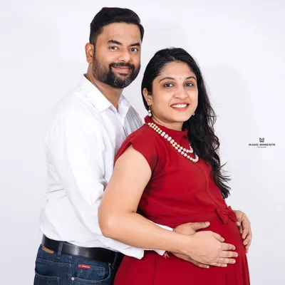 A classic couple's portrait against a clean white background. This style is timeless and puts all the focus on the expecting parents' happy expressions and connection.