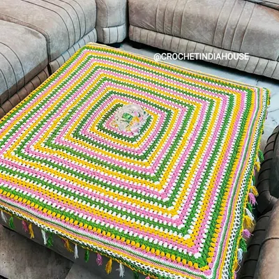 This large, square table cover was custom-made for a living room ottoman. The bright stripes and corner tassels add a playful and colorful touch to the space.