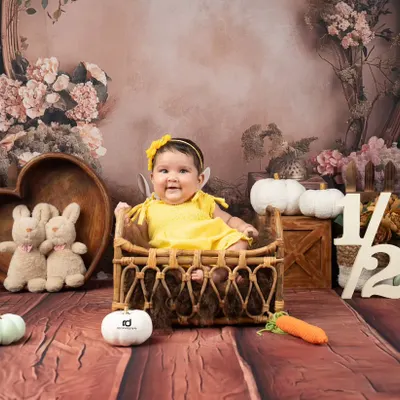 Halfway to one. This happy sitter-session baby is celebrating her six-month milestone with a bright yellow outfit and a charming rustic backdrop.