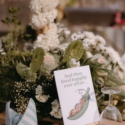 A sweet and personal touch on a table centerpiece placard, featuring a custom illustration of the couple and their beloved pet. We believe in celebrating the whole family.