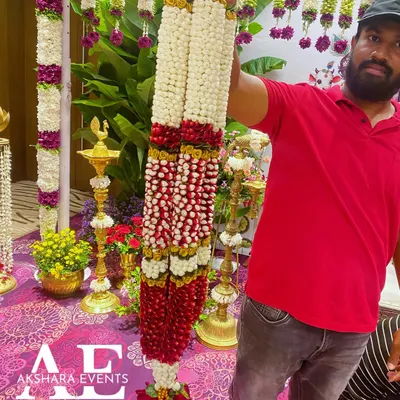 A very grand and heavy wedding garland I created, featuring thick strands of red and white flowers. This type of varmala is designed to be a magnificent part of the wedding attire.