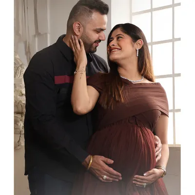 A tender moment between partners during their studio maternity shoot. The way they look at each other tells a story of love and shared anticipation for their new baby.