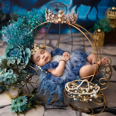 A close-up of a sleeping princess in her royal blue gown, adorned with pearls and a crown. I focus on capturing these peaceful expressions and tiny details during my newborn photography sessions.