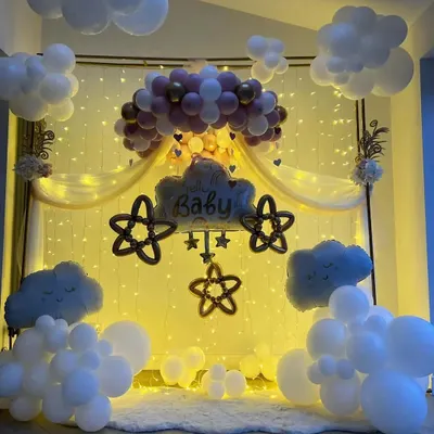 We created a magical sky for this "Baby" celebration. The backdrop glows with a curtain of fairy lights, while balloon clouds seem to float in the air, making the entire room feel like a sweet dream.