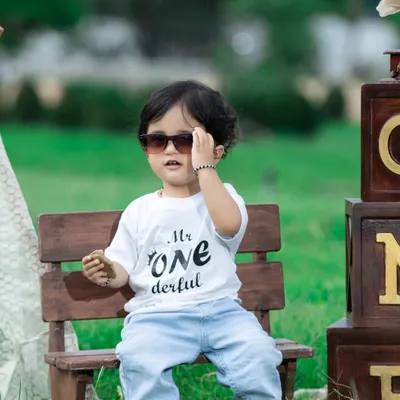 This 'Mr. ONEderful' is looking cool in his sunglasses during his outdoor birthday shoot. The natural light and greenery make for a beautiful portrait.