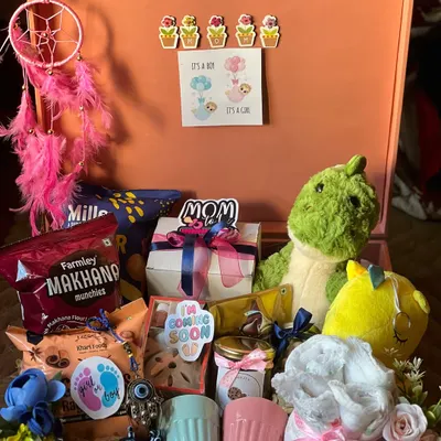 This mom-to-be trunk is filled with goodies for relaxation and celebration. It includes pampering items, healthy snacks like makhana, a dinosaur plush for the baby, and a dreamcatcher for good dreams.