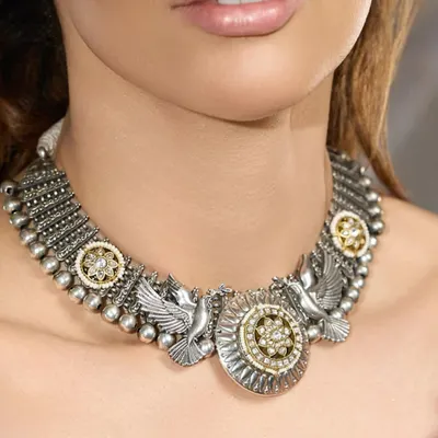 An heirloom of elegance, crafted to perfection. This oxidized silver choker features dove motifs and floral polki medallions, blending strength with delicate details.