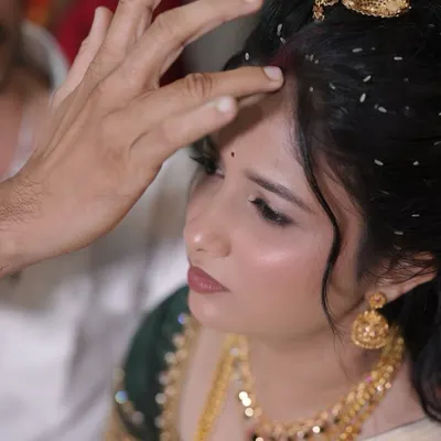 This close-up shows the flawless finish of the makeup during a wedding ritual. The skin looks smooth and radiant, not heavy or cakey, even under scrutiny.