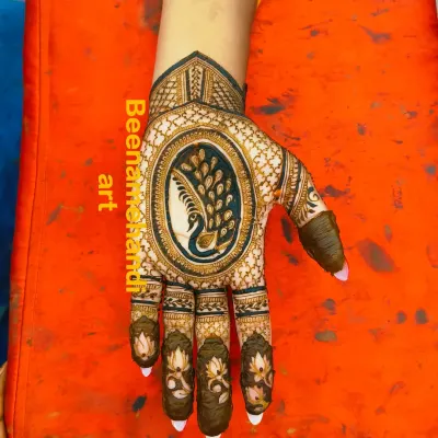 A stunning design with a large peacock as the centerpiece on the back of the hand. The fingers are decorated with delicate lotus motifs.