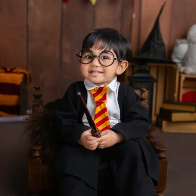 Expecto Patronum! This little wizard, dressed in his Hogwarts robe and glasses, is ready to cast a spell of cuteness in this magical Harry Potter themed photoshoot.