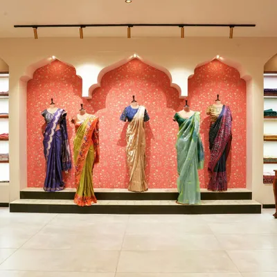 The main display wall at the 'House of Vaarasa' store. We used traditional Indian arched niches against a textured pink wall to create a stunning backdrop for the handloom sarees, making the products the heroes of the space.