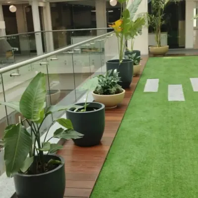 We designed this green corridor for a corporate office, using artificial turf and a series of large planters with Bird of Paradise and other foliage plants to create a natural and relaxing walkway.