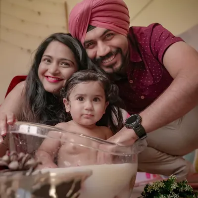 A happy family enjoying a fun milk bath photoshoot at home. This is a great example of a creative and playful themed session I can set up right in your living room.