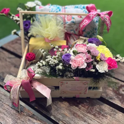 A "Get Well, Beautifully" hamper, designed to bring comfort and cheer. This pine basket is filled with soft textiles, soothing treats, and a vibrant bouquet of fresh flowers to brighten their recovery.