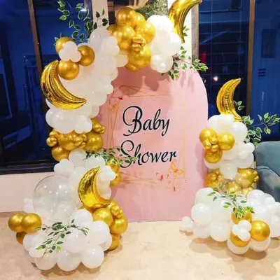 A dreamy "Baby Shower" decoration with a "Twinkle Twinkle Little Star" vibe. This setup features a pink arched backdrop, a white and gold balloon garland, and crescent moon foil balloons.